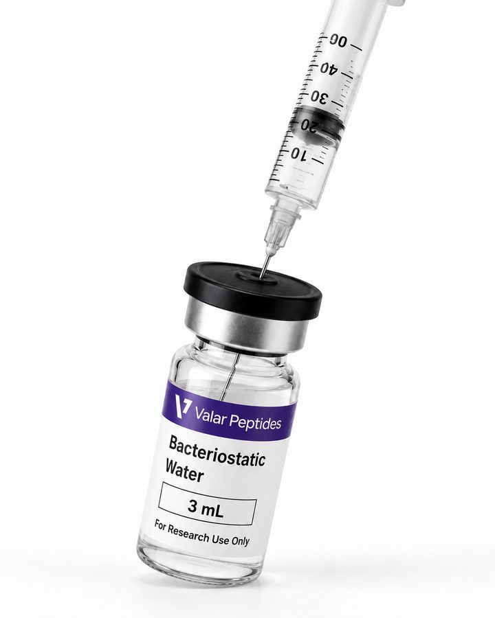 A syringe drawing bacteriostatic water from a vial